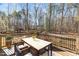 Outdoor deck with a dining table and chairs overlooking the wooded area at 76 Gentry Dr, Pittsboro, NC 27312