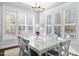 Dining room with large windows, white furniture, and contemporary chandelier at 76 Gentry Dr, Pittsboro, NC 27312