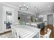 Dining area with white table and chairs adjoins kitchen and living room with staircase at 76 Gentry Dr, Pittsboro, NC 27312