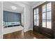 Inviting foyer with beautiful paneled wood doors and view to bench seating area with a blue accent wall at 76 Gentry Dr, Pittsboro, NC 27312