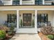 Charming front porch with rocking chairs, decorative plants, and double door entry at 76 Gentry Dr, Pittsboro, NC 27312