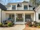 Charming front porch with rocking chairs, decorative plants, and double door entry at 76 Gentry Dr, Pittsboro, NC 27312