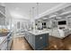 Modern kitchen with granite island and seating flows into a living room with fireplace and coffered ceilings at 76 Gentry Dr, Pittsboro, NC 27312