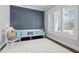 Comfortable sitting room with blue paneled accent wall, white bench with decorative pillows and natural light at 76 Gentry Dr, Pittsboro, NC 27312