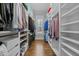 Spacious walk-in closet with custom shelving, cabinets and wood floors at 76 Gentry Dr, Pittsboro, NC 27312