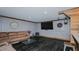 Cozy basement featuring a comfy leather couch, mounted television and dark laminate flooring at 761 S Eighth St, Mebane, NC 27302