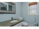 Powder blue bathroom offers a stone countertop, toilet, mirror, and bamboo blind at 761 S Eighth St, Mebane, NC 27302