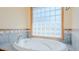 Soaking tub sits beneath a glass block window and decorative tiled backsplash at 761 S Eighth St, Mebane, NC 27302