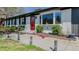 Beautiful white brick home with a bright red front door, bay window, and professionally landscaped walkway at 761 S Eighth St, Mebane, NC 27302