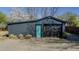 Detached garage with black siding, black garage door, and turquoise door in an outdoor setting with plants at 761 S Eighth St, Mebane, NC 27302