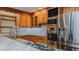 Well-equipped kitchen featuring stainless steel appliances, wooden cabinets, and a mosaic tile backsplash at 761 S Eighth St, Mebane, NC 27302