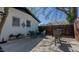 A view of the backyard patio with seating, a white brick home, and a wooden fence at 761 S Eighth St, Mebane, NC 27302