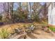 Landscaped backyard features pea gravel patio with comfortable seating, fire pit, and string lights at 7816 Tylerton Dr, Raleigh, NC 27613