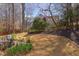 Lush backyard featuring patio, mature trees, and a charming wood fence at 7816 Tylerton Dr, Raleigh, NC 27613