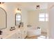 Bright bathroom featuring a soaking tub, double vanity with modern fixtures, and light wood floors at 7816 Tylerton Dr, Raleigh, NC 27613
