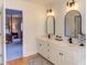 Bathroom featuring a double vanity with modern fixtures, with an open door to a bedroom at 7816 Tylerton Dr, Raleigh, NC 27613