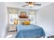 Cozy bedroom with a blue quilt, decorative pillows, and windows providing natural light at 7816 Tylerton Dr, Raleigh, NC 27613