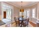 Charming dining room with wood floors, a circular table, and access to both the kitchen and backyard at 7816 Tylerton Dr, Raleigh, NC 27613