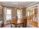 Formal dining room with hardwood floors, elegant chandelier, and a view of the staircase at 7816 Tylerton Dr, Raleigh, NC 27613