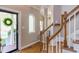 Elegant foyer featuring hardwood floors, staircase, and an arched window, creating a warm and inviting entrance at 7816 Tylerton Dr, Raleigh, NC 27613