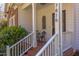 Inviting front porch with brick flooring, white railings, and a cozy seating area with wrought iron furniture at 7816 Tylerton Dr, Raleigh, NC 27613