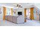 Spacious living room with a large sectional sofa, ceiling fan and bright windows at 7816 Tylerton Dr, Raleigh, NC 27613