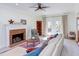 Bright living room boasting a brick fireplace, ceiling fan, plush seating, and access to the outdoors at 7816 Tylerton Dr, Raleigh, NC 27613