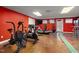 Finished basement featuring gym equipment on a stained concrete floor and red accent wall at 7917 Holly Springs Rd, Raleigh, NC 27606