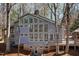 Exterior of gray two-story home featuring lots of windows and lush wooded surroundings at 7917 Holly Springs Rd, Raleigh, NC 27606