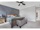 Beautiful bedroom featuring a stylish accent wall, ceiling fan, and neutral decor at 83 Inspiration Way, Fuquay Varina, NC 27526
