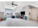 Spacious bonus room with a ceiling fan, TV, play area, and ample natural light at 83 Inspiration Way, Fuquay Varina, NC 27526