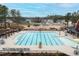 Expansive community pool area with lounge chairs, umbrellas, and surrounding neighborhood landscape under a clear sky at 83 Inspiration Way, Fuquay Varina, NC 27526