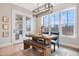 Dining room with rustic table set for a meal with modern light fixture and large windows at 83 Inspiration Way, Fuquay Varina, NC 27526