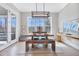 Dining room with rustic wooden table, bench, chairs, modern lighting, and sliding glass door at 83 Inspiration Way, Fuquay Varina, NC 27526