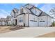 Spacious home with a three-car garage, showcasing modern design and a well-manicured lawn at 83 Inspiration Way, Fuquay Varina, NC 27526