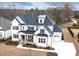 Aerial view of a two-story home featuring painted brick, a black roof, and an attached two-car garage at 83 Inspiration Way, Fuquay Varina, NC 27526