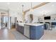 Kitchen island with stainless steel dishwasher, farm sink and views to living room and stairs at 83 Inspiration Way, Fuquay Varina, NC 27526