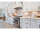 Bright kitchen boasts white cabinets, stainless steel appliances, tiled backsplash, and modern hardware at 83 Inspiration Way, Fuquay Varina, NC 27526