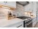 Close up of Kitchenaid stainless steel oven and range with light grey tiled backsplash and white countertops at 83 Inspiration Way, Fuquay Varina, NC 27526