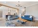 Open-concept living room with hardwood floors and a stylish rug, seamlessly connecting to the kitchen at 83 Inspiration Way, Fuquay Varina, NC 27526