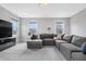 Spacious living room featuring an oversized gray sectional sofa and multiple windows at 83 Inspiration Way, Fuquay Varina, NC 27526