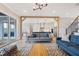 Bright and airy living room with open access to kitchen, featuring hardwood floors and designer lighting at 83 Inspiration Way, Fuquay Varina, NC 27526