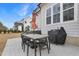 Outdoor patio with an umbrella-covered table, grill, and a view of the backyard playset and hot tub at 83 Inspiration Way, Fuquay Varina, NC 27526