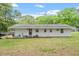 Rear exterior showcasing a patio area, well-maintained lawn, and access to the backyard at 911 Williams Rd, Raleigh, NC 27610
