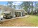 Well-maintained white house with a covered parking area and a cozy patio seating area at 911 Williams Rd, Raleigh, NC 27610