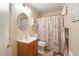 Compact bathroom with a modern sink, toilet, and a shower with a patterned curtain at 911 Williams Rd, Raleigh, NC 27610