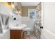 A cozy bathroom featuring white tile, a pedestal sink, and a floral shower curtain at 105 Blanchard St, Fuquay Varina, NC 27526