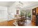 Elegant dining room featuring a rustic wooden table, modern light fixture, and sunroom access at 105 Blanchard St, Fuquay Varina, NC 27526