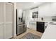 Well-lit kitchen with stainless steel refrigerator, white cabinets, and black dishwasher at 105 Blanchard St, Fuquay Varina, NC 27526
