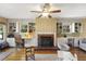 Multipurpose living room featuring a fireplace, built-in bookcases, and workspace at 105 Blanchard St, Fuquay Varina, NC 27526